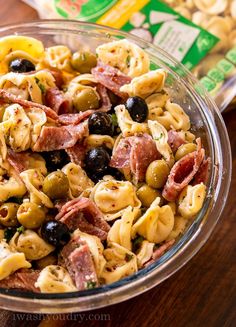 pasta salad with olives and ham in a glass bowl