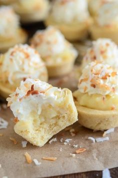 coconut cream filled cupcakes sitting on top of a piece of brown parchment paper