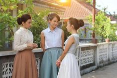 three women standing next to each other talking