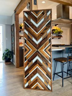 a room divider made out of wood in the middle of a living room and kitchen