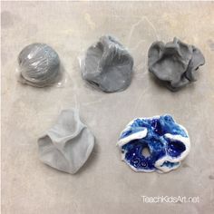 four different shapes and sizes of rocks on a table with plastic wrappers around them