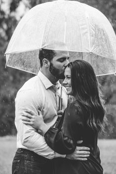 black and white photograph of a couple under an umbrella in the rain with their arms around each other