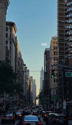 a city street filled with lots of traffic next to tall buildings on either side of the road