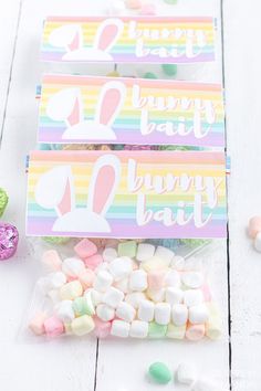 three bags filled with candy and marshmallows on top of a white table