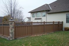 a brown wooden fence in front of a house