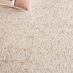 a white carpet with a pillow on top of it