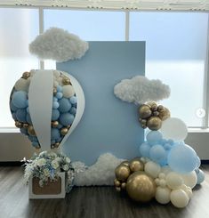 balloons and clouds are arranged in the shape of a heart on a blue backdrop with white trim