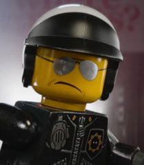 a lego man wearing a helmet and holding his hand up to the side with one eye open