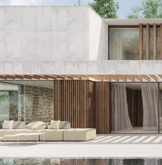 a large white couch sitting in front of a pool next to a building with windows