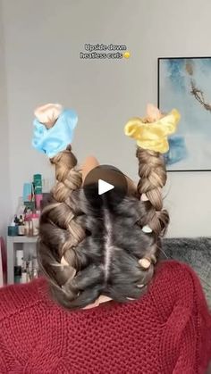 the back of a woman's head with two braids in it