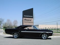 a black car parked in front of a sign