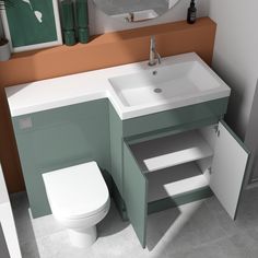 a white sink sitting under a bathroom mirror next to a toilet and counter top with drawers