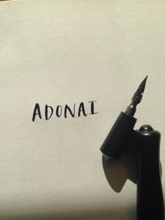 an old typewriter with the word adonal written on it next to a fountain pen