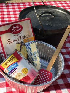 an aluminum pan filled with baking ingredients on top of a checkered red and white table cloth