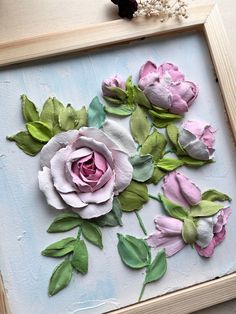 some pink and green flowers are in a frame