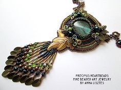 a necklace made with beads and feathers on a white background, reads precious materials the bead art jewelry by amanda loziers