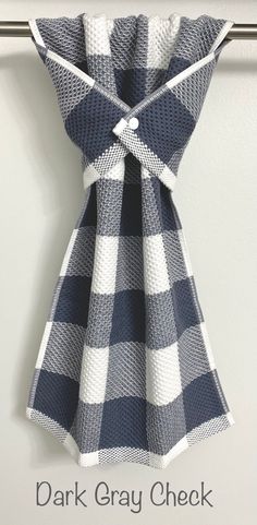 a black and white checkered dress hanging on a wall with the words dark gray check