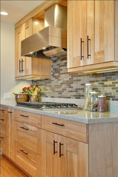 a kitchen with wooden cabinets and granite counter tops, along with an oven hood over the stove