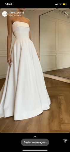 a woman in a white dress standing on a wooden floor