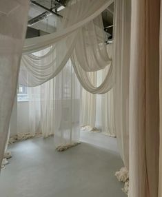 an empty room with sheer curtains on the walls