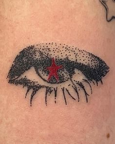 a woman's upper arm with an eye and star on the bottom part of it