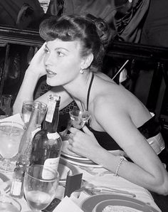 two women sitting at a table with wine glasses