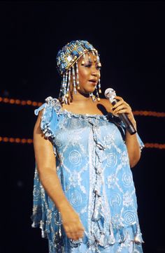 a woman in blue dress holding a microphone