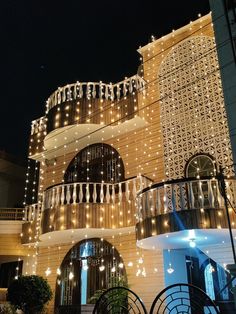 a large building with lights on it's sides and balconies above the balconies