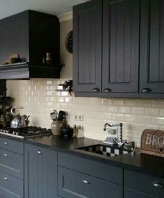 a kitchen with gray cabinets and black counter tops is seen in this image from the front view