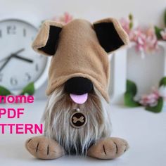 a small stuffed dog sitting in front of a clock