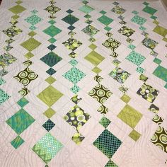 a green and white quilt on top of a bed