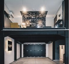 an empty garage with black doors and white walls