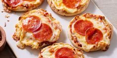 mini pizzas with cheese and pepperoni on a white plate