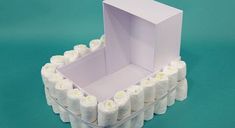 an open box with white candles inside on a blue background in the shape of a toothbrush holder