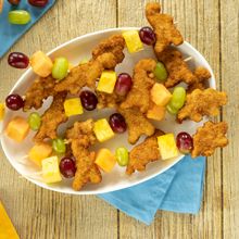 a white plate topped with chicken nuggies and fruit