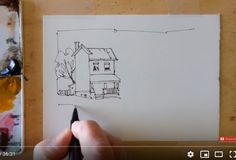 someone is drawing a house on paper with a marker