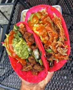 two tacos with meat, guacamole and sauce