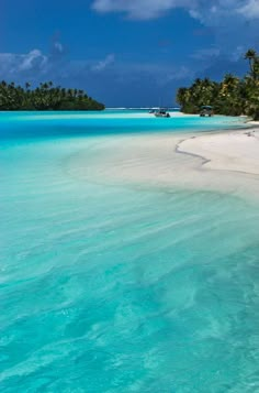 the water is crystal blue and clear with white sand on it, surrounded by palm trees