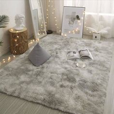 a living room with white furniture and lights on the windowsill, rugs and pictures