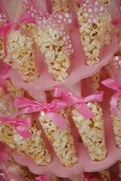 there are many candy sticks with pink bows on the top and one is made out of rice krispy kreme