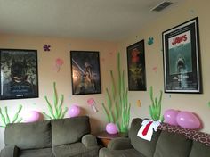 the living room is decorated with balloons and pictures on the wall above the couches