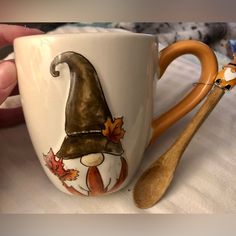 a coffee cup with a wooden spoon sitting on top of it next to a ceramic mug