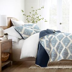 a bed with blue and white comforters in a bedroom