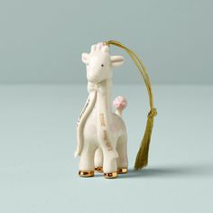 a ceramic giraffe ornament with a tassel hanging from it's neck