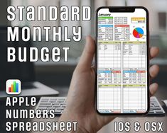 a hand holding an iphone with the text standard monthly budget on it and a spreadsheet next to it