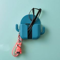 a cell phone holder with a pair of glasses hanging from it's back end