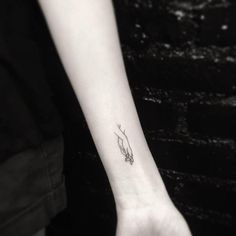 a woman's arm with a small tattoo on the left side of her wrist