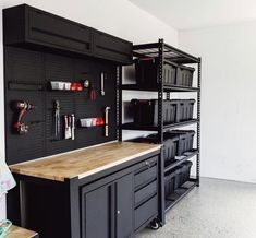 an organized garage with black cabinets and shelves