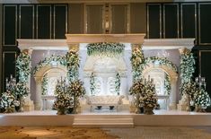 a wedding stage decorated with flowers and greenery