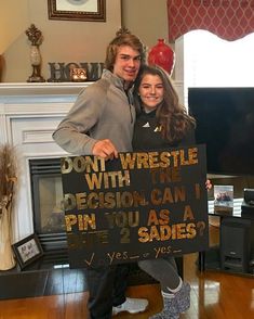 a man and woman standing next to each other holding a sign that says don't wrestle with the decision can i pin you as a fine 2 sides?